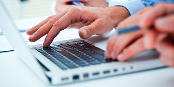 Händer skriver på dator.