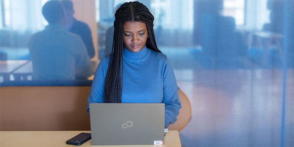 Medarbetare sitter och skriver på dator. Foto: Susanne Kronholm.